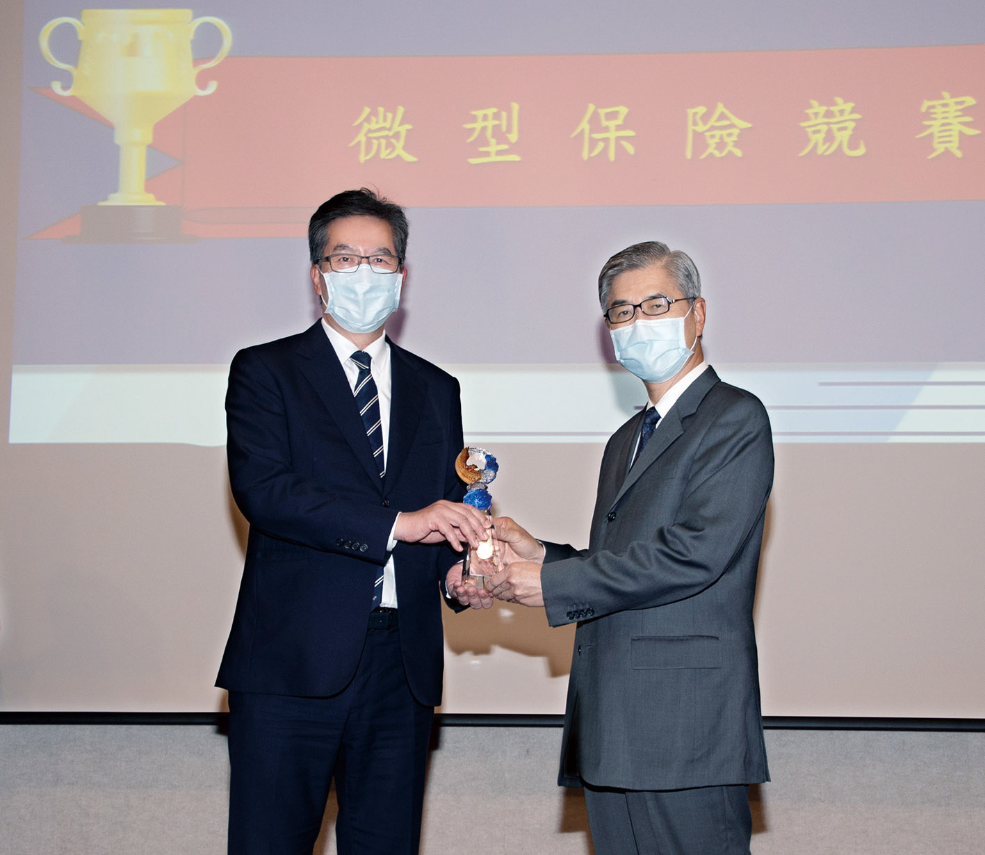 永達保經獲得2021年微型保險競賽-保險輔助人組第一名，由金融監督管理委員會主委黃天牧（右）頒獎，永達陳慶鴻總經理（左）代表受獎。