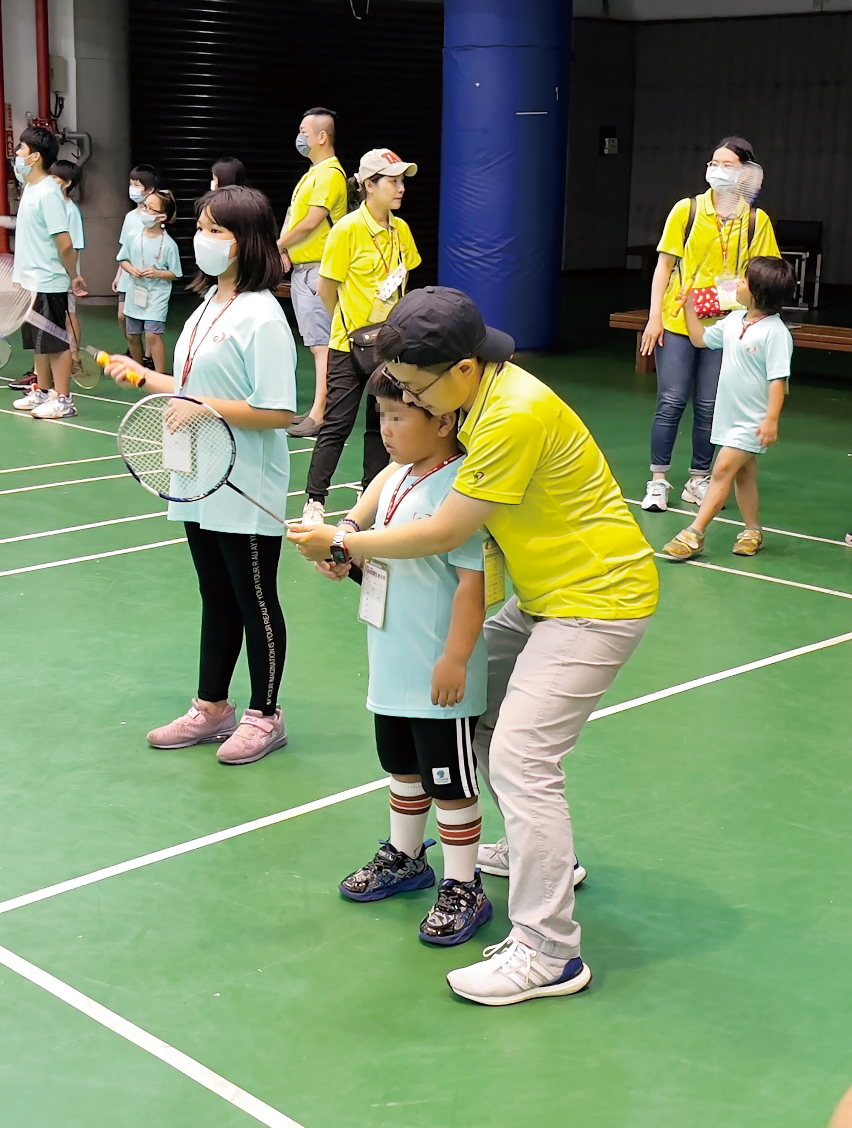 志工用愛心和耐心陪伴寶貝練習羽球。
