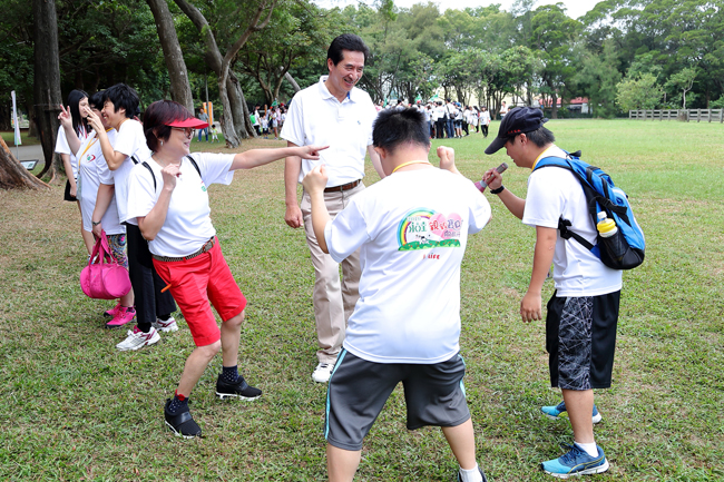 (左一)台灣優質生命協會紀寶如秘書長、永達保經陳慶鴻總經理與可愛的憨兒寶貝 愉快的在草皮上嬉戲。