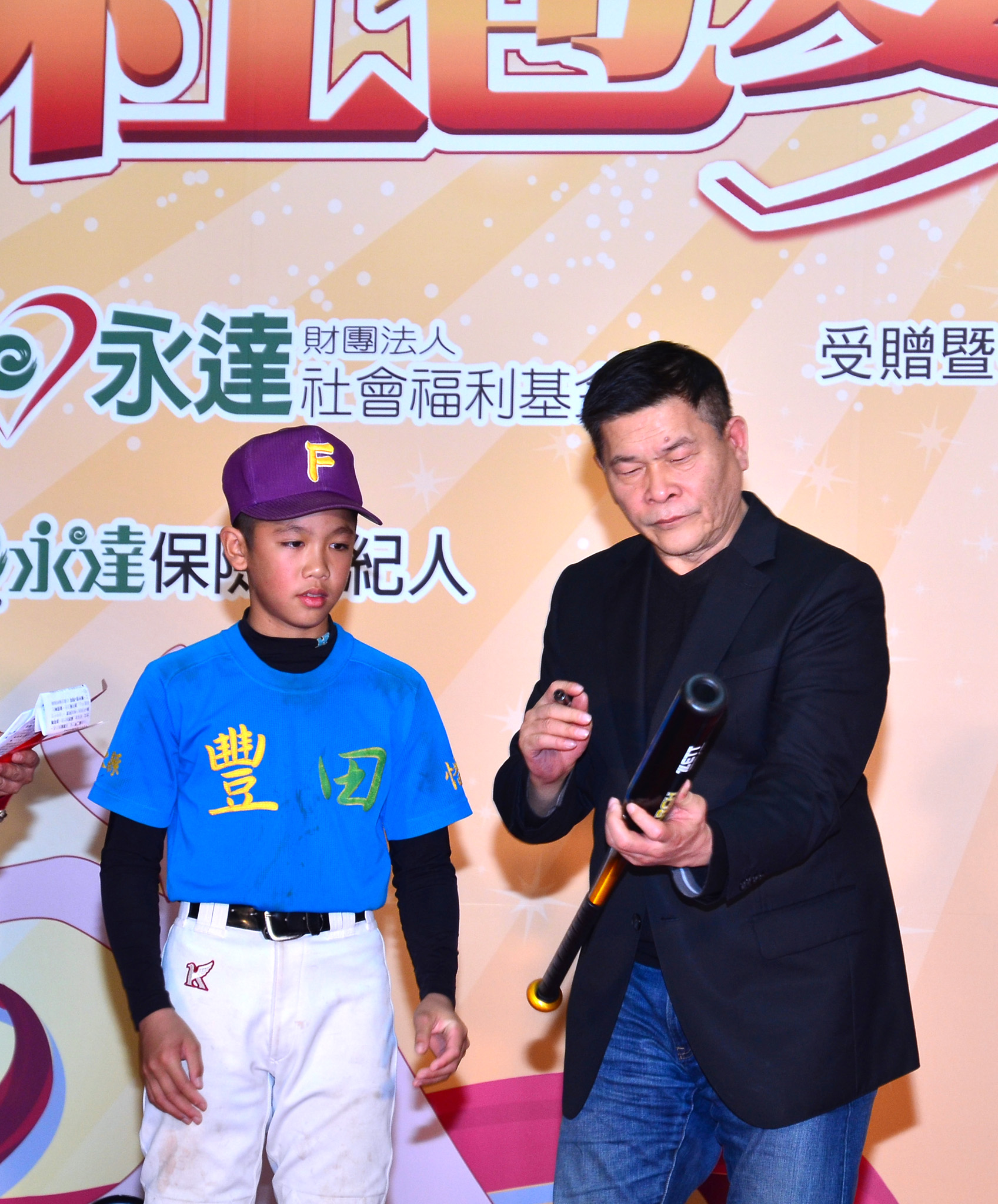 澎恰恰為台東阿美族少年阿清於球棒上簽名，鼓勵他努力練球。