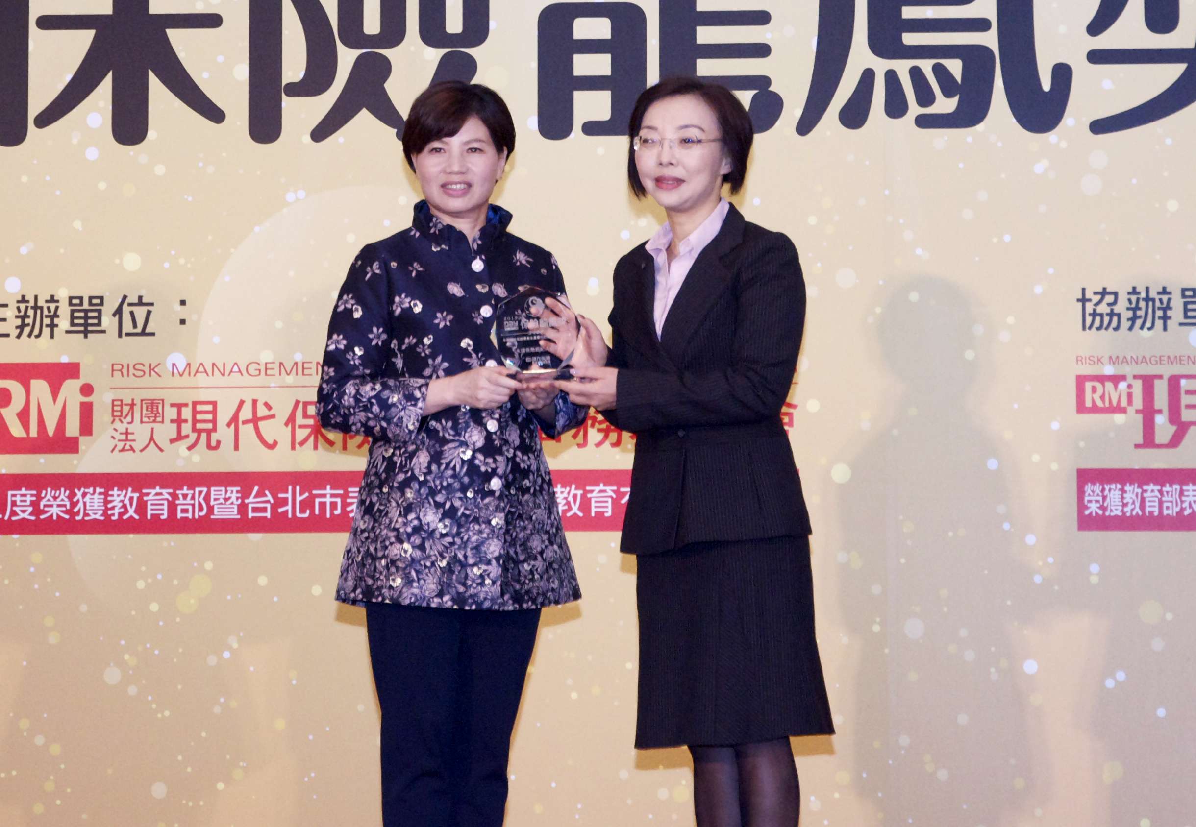 永達保經副總李淑媛(右)接受由現代保險教育事務基金會董事長林麗銖(左)頒發保險龍鳳獎。。