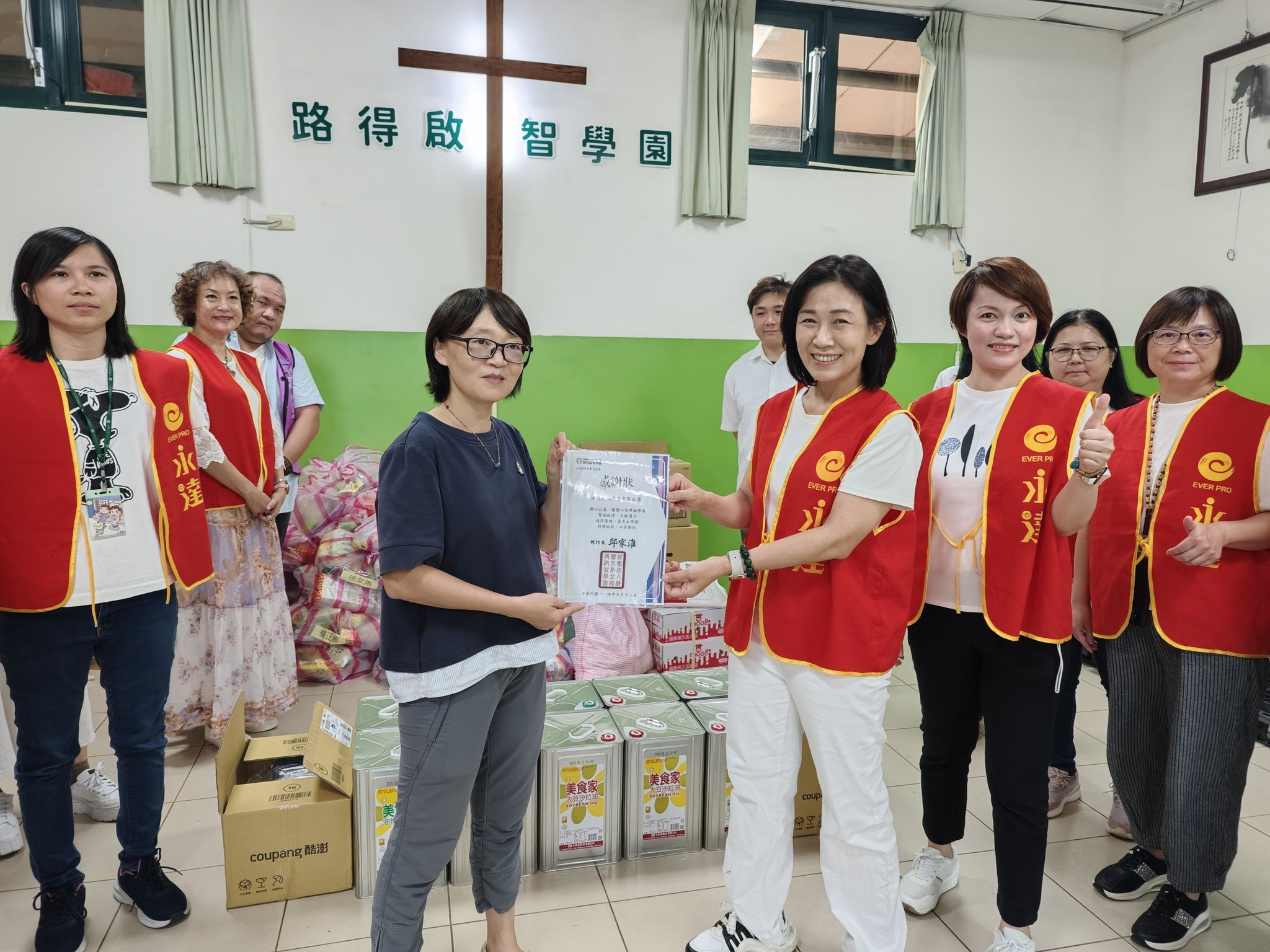 由永達保經高慧如業務協理(右三)帶領單位夥伴擔任志工，並捐贈物資乙批由路得啟智學園廖櫻芳秘書長(左二)代表受贈。