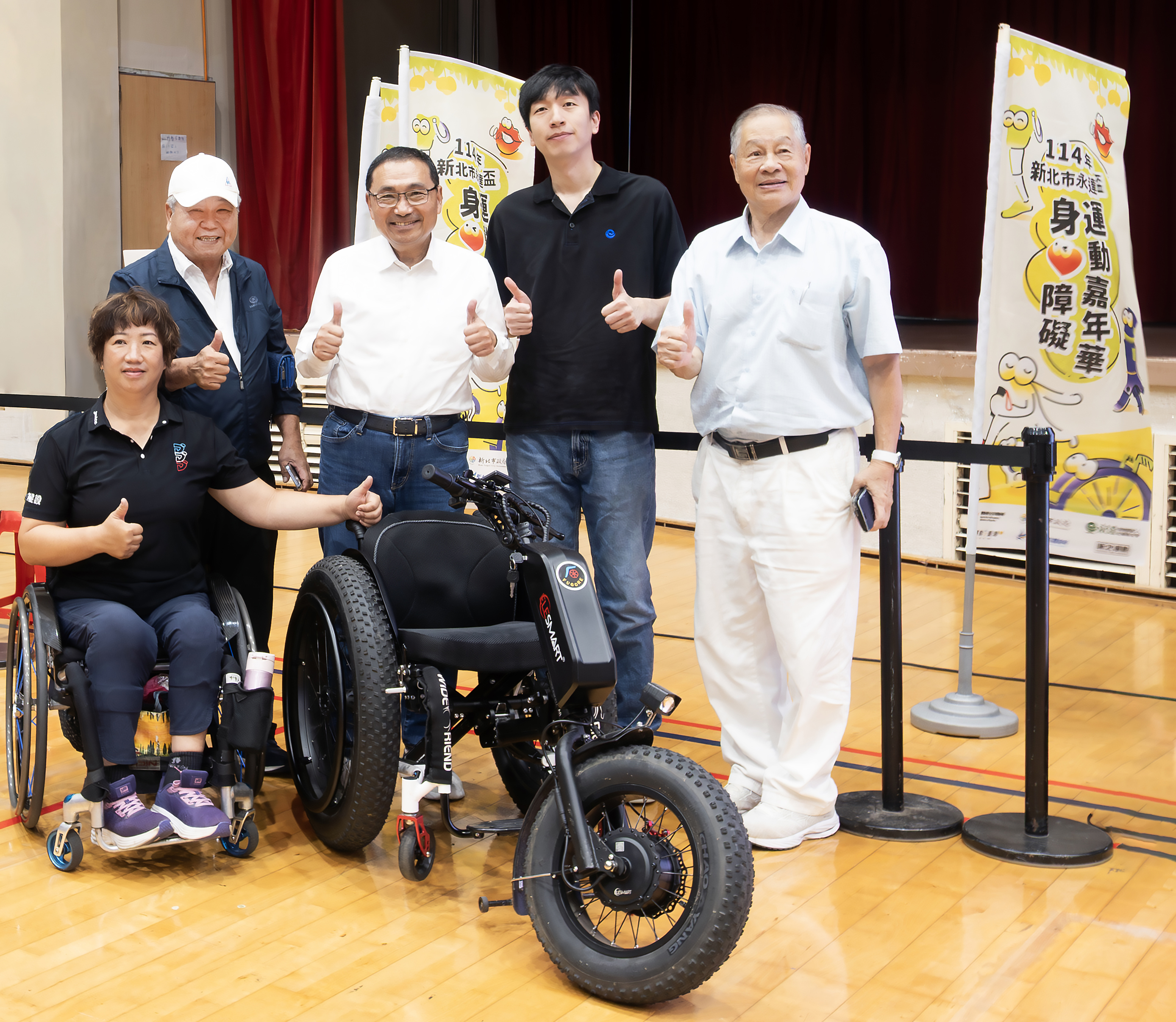 (左3起)侯友宜市長、吳柏瑨總經理特助、(左1起)呂嘉儀營運長,中華民國身心障礙者休閒運動推廣協會劉耀台副理事長、(左5)張思敏名譽理事長與本次捐贈的沙灘輪椅合影留念。