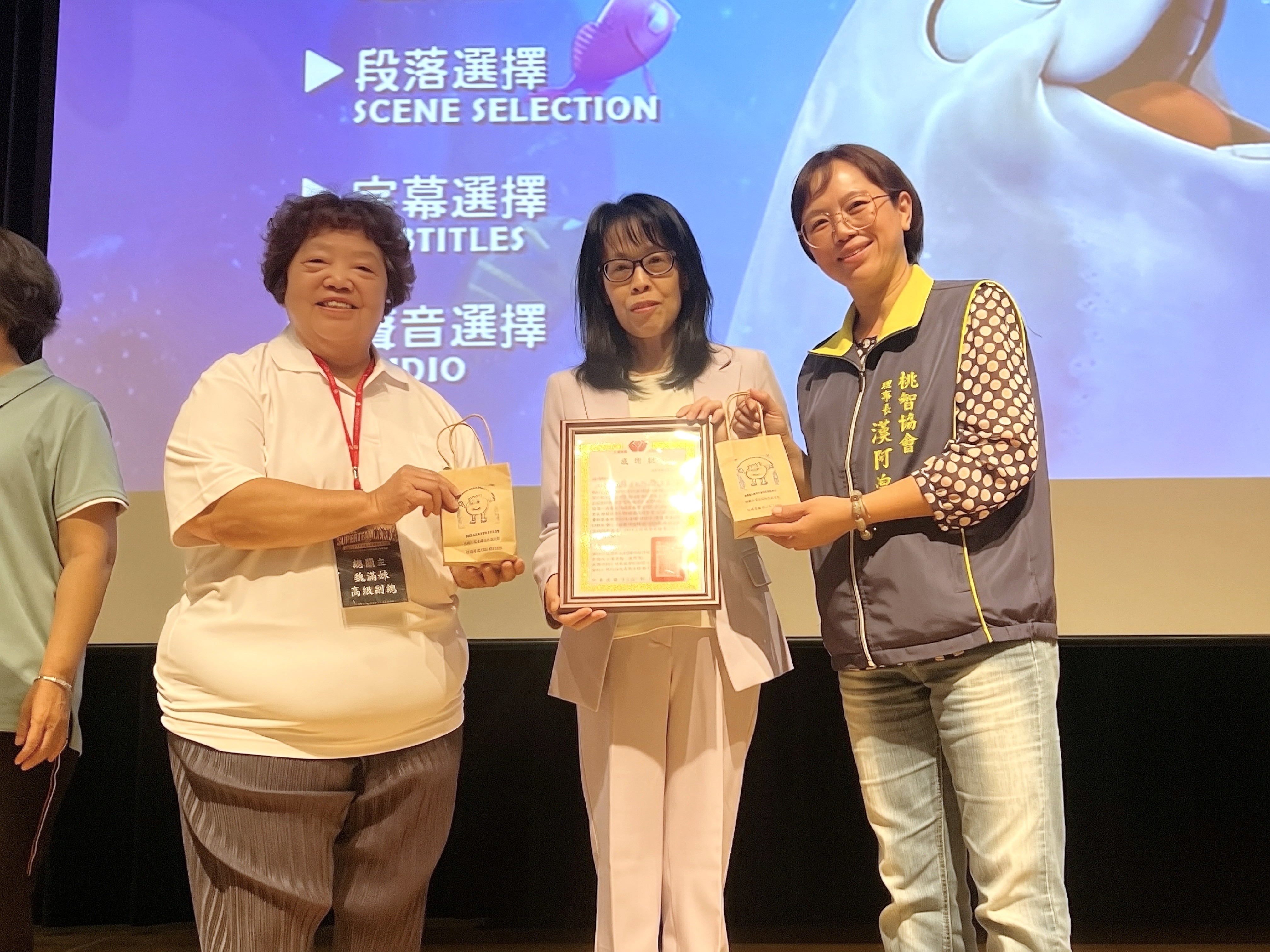 桃園市智障者家長協會漢阿煌理事長（右）準備院生自製的小禮物致贈永達保經魏滿妹業務高級副總（左）及永達社福基金會羅怡如秘書長（中）。