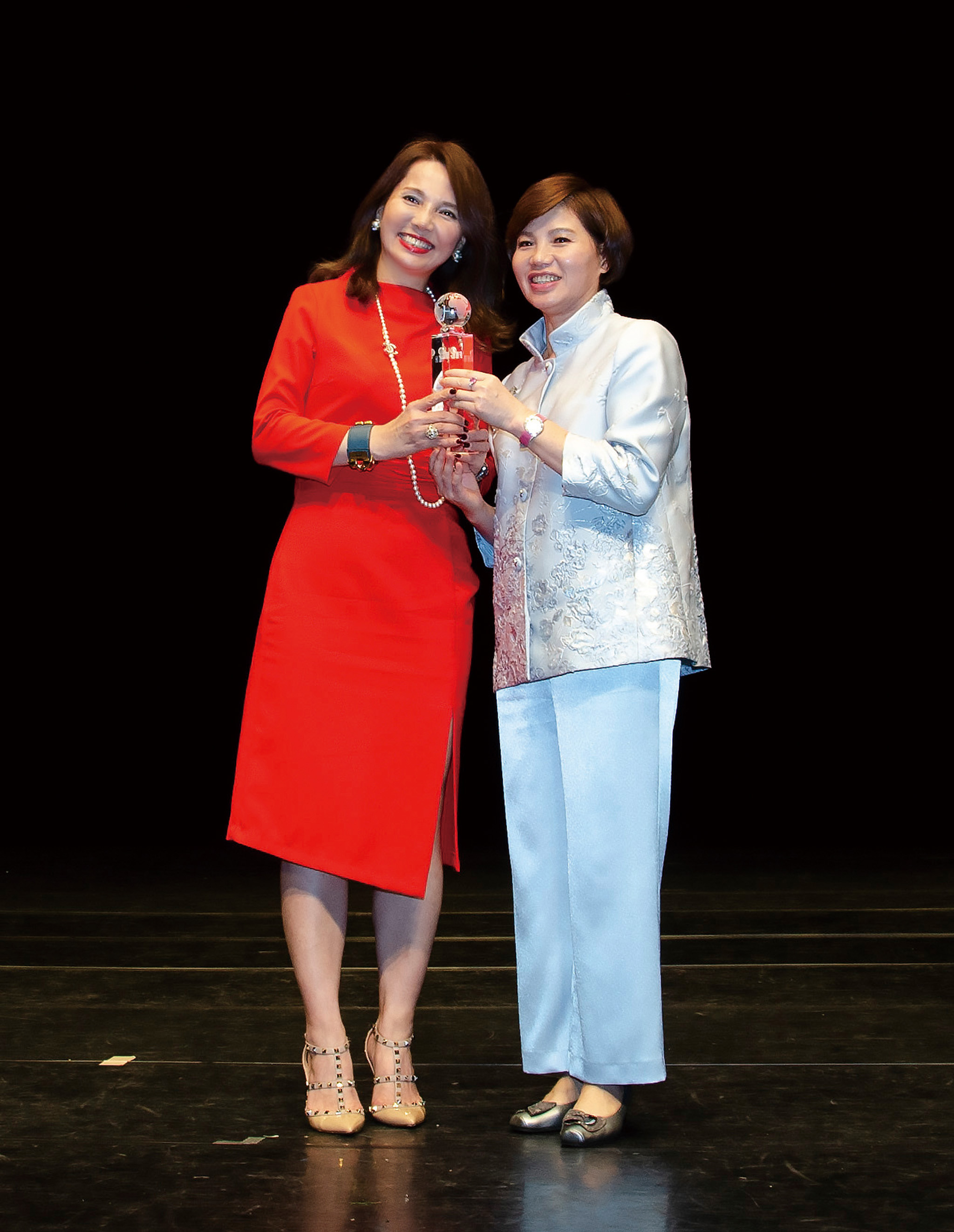 陳翠芳業務協理（左）從現代保險健康理財雜誌發行人林麗銖（右）手中接下「最佳通訊處」特優獎盃。