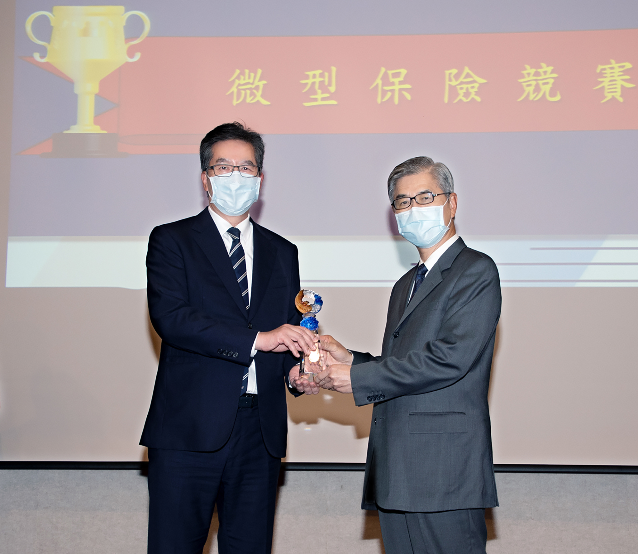 永達保經獲得2021年微型保險競賽-保險輔助人組第一名，由金融監督管理委員會主委黃天牧（圖右）頒獎，永達陳慶鴻總經理（圖左）代表受獎。