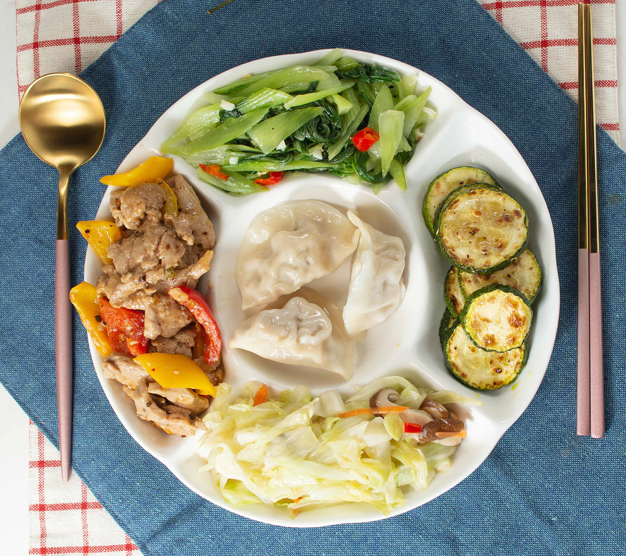 水餃餐盤：水餃、彩椒炒肉片、炒青江菜、煎櫛瓜、炒高麗菜。