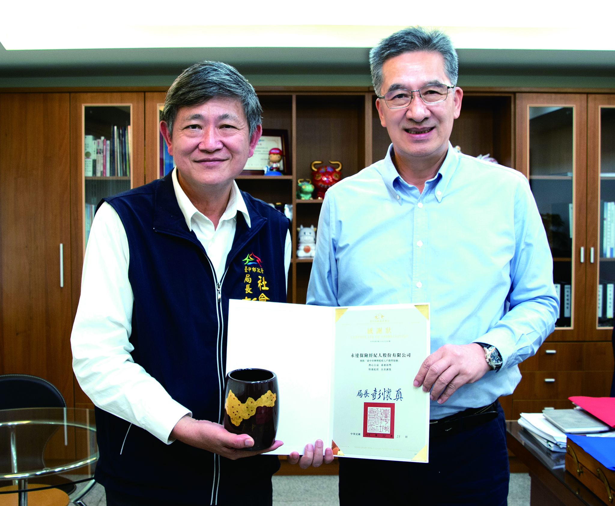 台中市政府社會局彭懷真局長（圖左）贈送感謝狀，由永達陳慶鴻總經理（圖右）代表受獎。