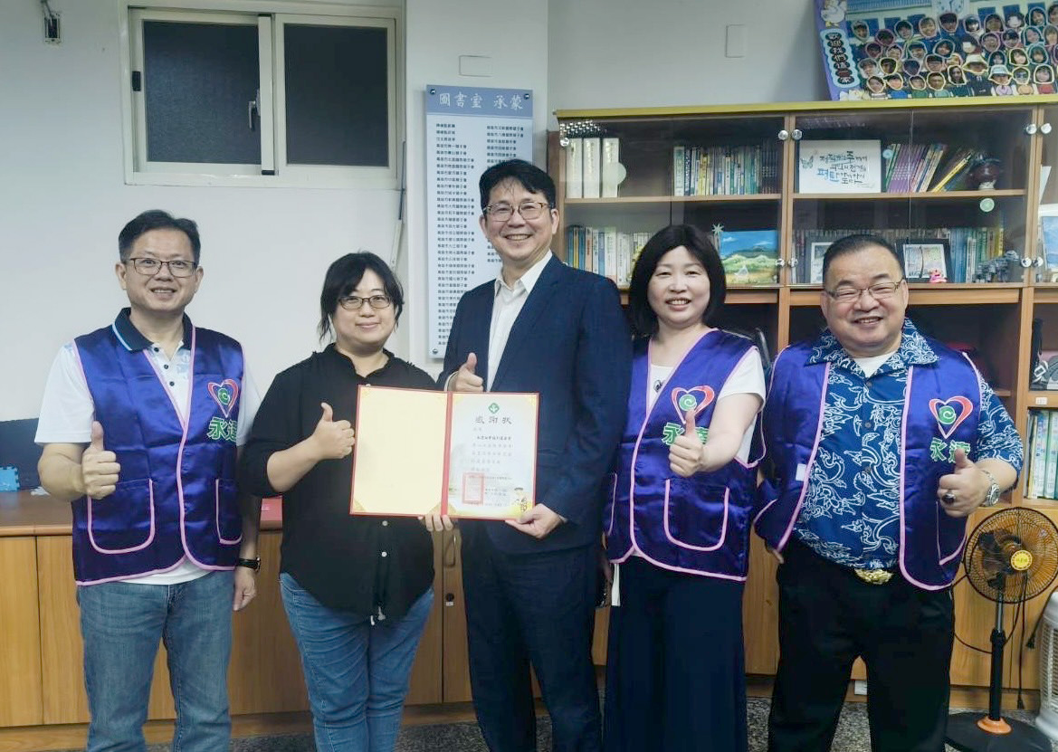 高雄市紅十字會育幼中心林瑛凰院長(左2)頒贈感謝狀,由永達保經高文山業務副總(中)代表受贈,與陳慧雯業務籌備副總(右2)、蔡明宏業務協理(左1)、張富強業務籌備協理(右1)合影留念。