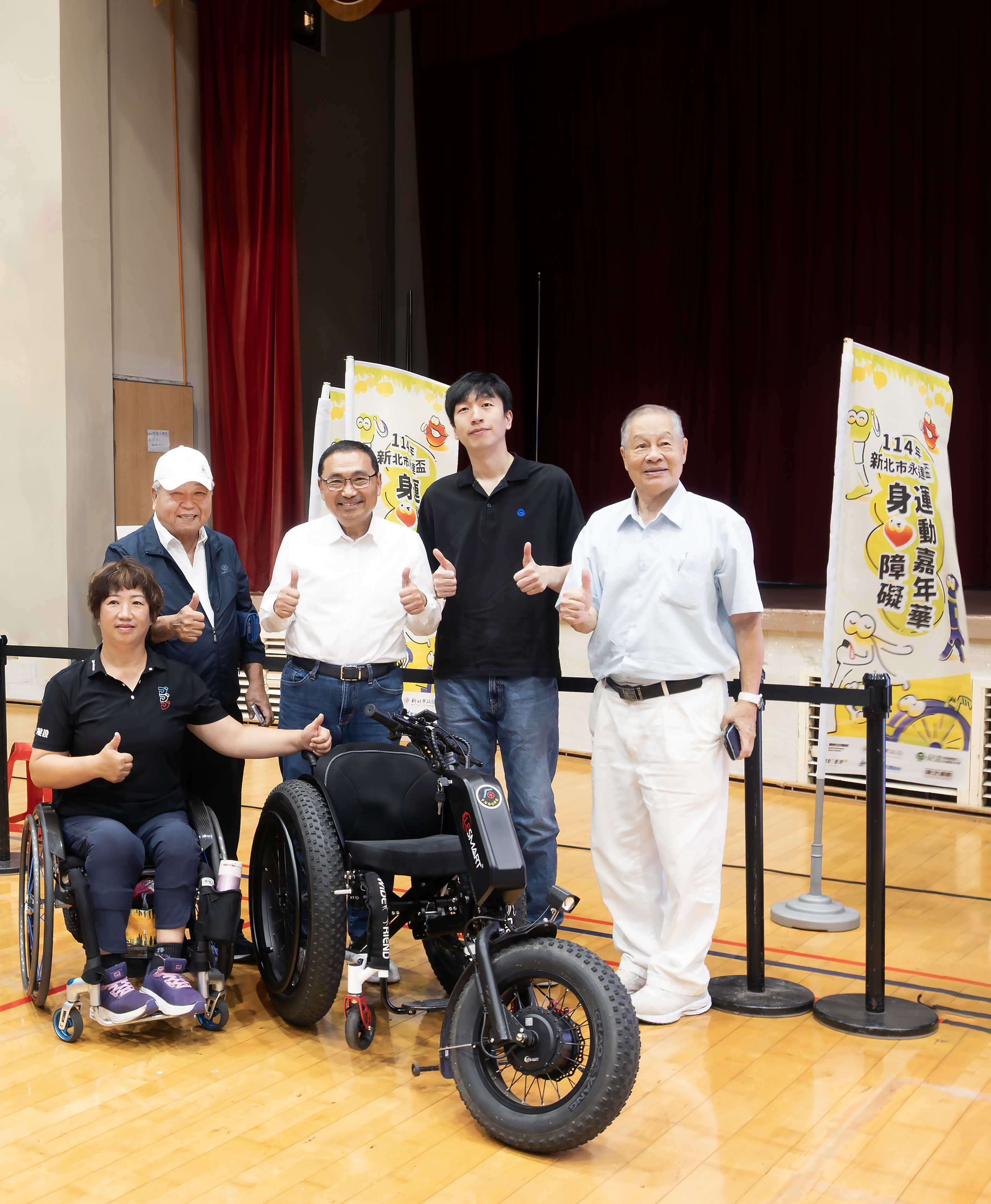 （左3 起）侯友宜市長、吳柏瑨總經理特助、（左1 起）呂嘉儀營運長，中華民國身心障礙者休閒運動推廣協會劉耀台副理事長、（右1）張思敏名譽理事長與本次捐贈的沙灘輪椅合影留念。